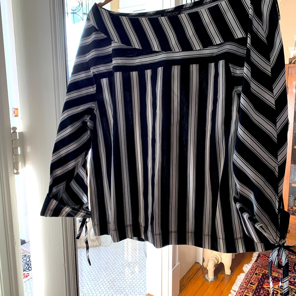 Blouse. Slightly off shoulder. Tied cuffs. Pleated back